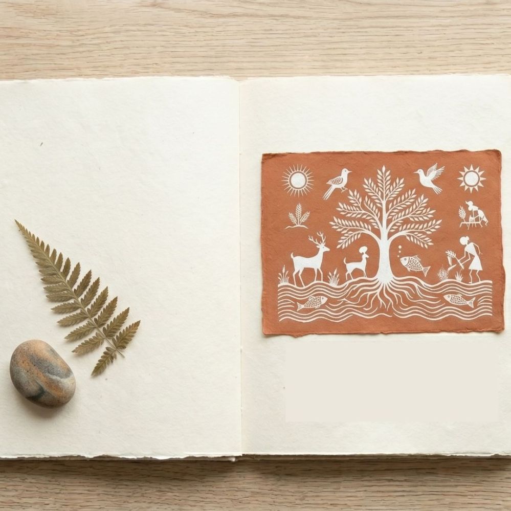 Warli art of a sacred tree with roots and animals, symbolizing the spiritual connection between community and nature.